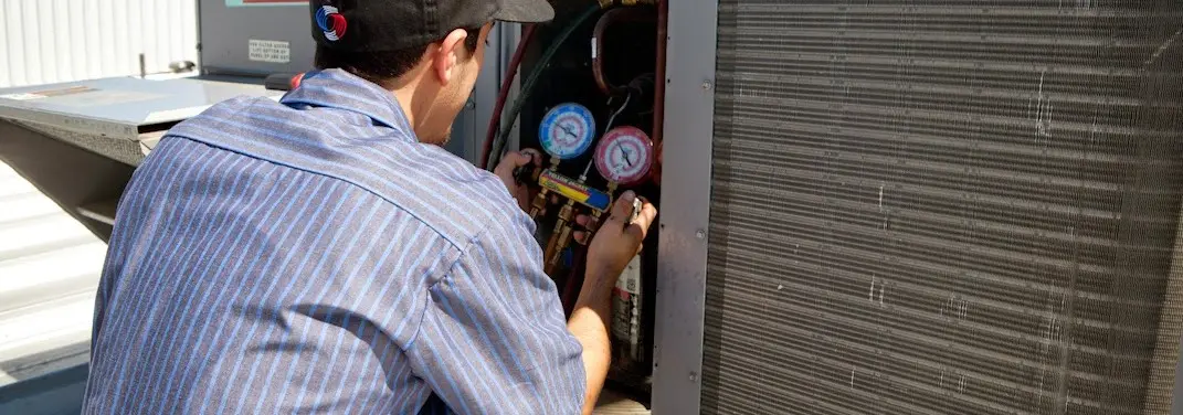HVAC technician servicing a condenser unit in Richfield