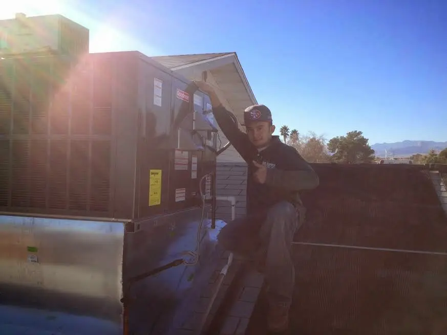 HVAC technician performing AC Tune-Up on a rooftop unit in Richfield